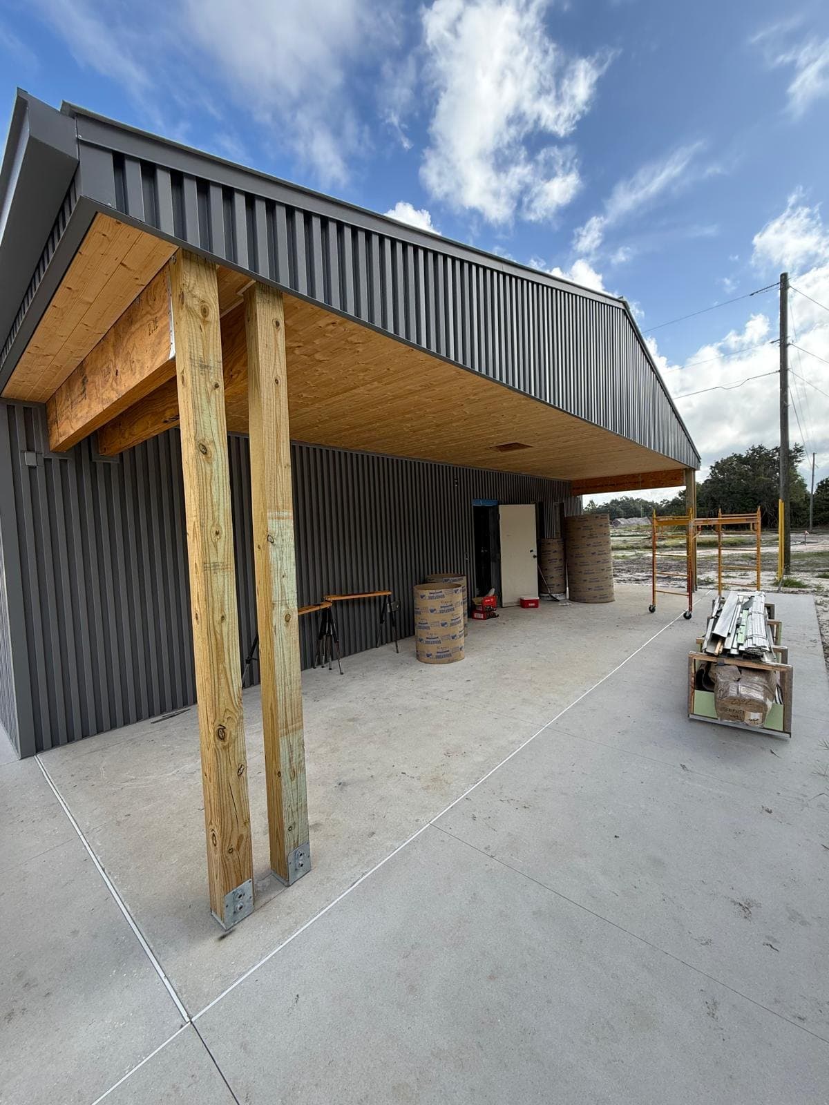 Commercial entry canopy with painted wood column and metal panel